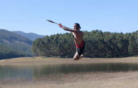 Indian fighter with lance jumping up during Kalaripayattu marital art demonstration in Kerala, South Indiaの写真素材