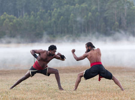 Indian fighters performing Adi Thada (Hand Combat) during Kalaripayattu Marital art demonstration in Kerala, South Indiaの写真素材