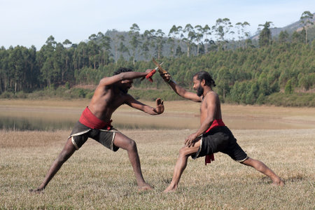 Indian fighters performing Aayudha Payattu (Weapon Combat) during Kalaripayattu Marital art demonstration in Kerala, South Indiaの写真素材