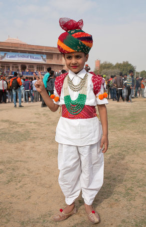 BIKANER, INDIA - JANUARY 12, 2019: Smiling Indian boy in traditional Rajasthani clothes poses for a photo during Camel Festival in Rajasthan stateのeditorial素材