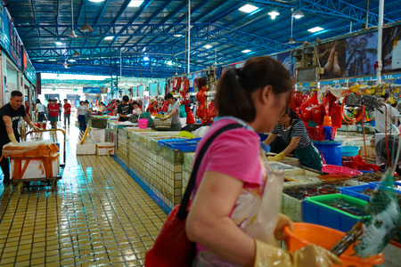 People working and shopping in a seafood market in chinaのeditorial素材