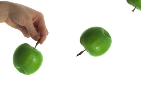 The thrown green tasty-looking apple from hand isolated on whiteの写真素材
