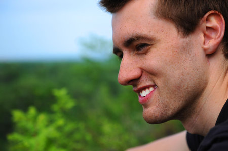 Close-up. The beautiful young smiling man of the outdoorsの写真素材