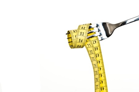 Diet concept. Metallic fork with measure on white backgroundの写真素材