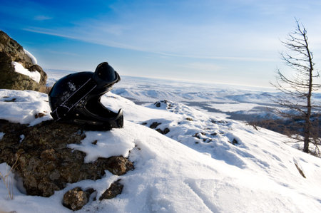 Helmet on mountains with blue sky in backgroundの写真素材