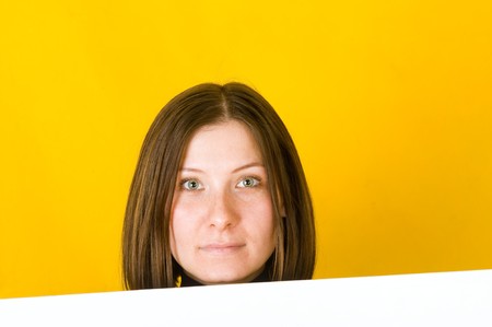 Beautiful woman looking at camera. On yellow backgroundの写真素材