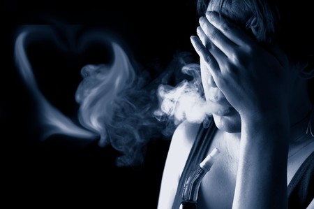 Portrait of sad woman smoking in the darknessの写真素材