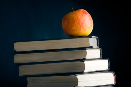 A red apple on a books over black backgroundの写真素材