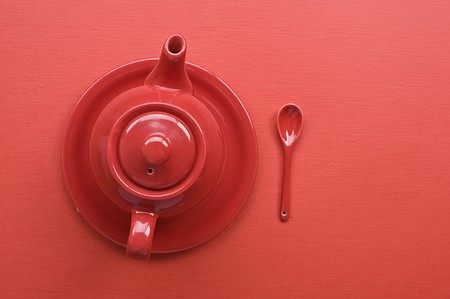 Teapot and spoon on red tableの写真素材