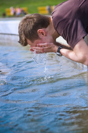 Close-up portrait of young man wash in a fountainの写真素材