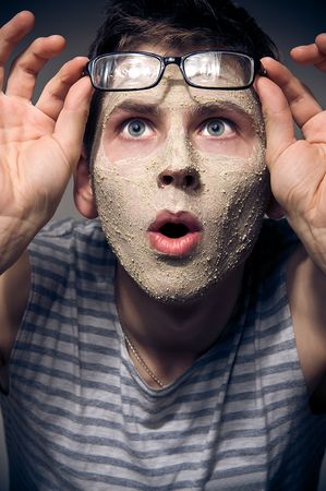 Close-up portrait of funny man with facial mask and glassesの写真素材