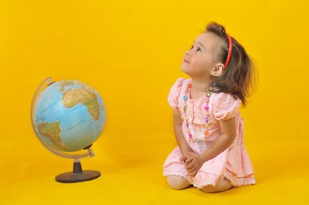 Baby and globe on the yellow backgroundの写真素材