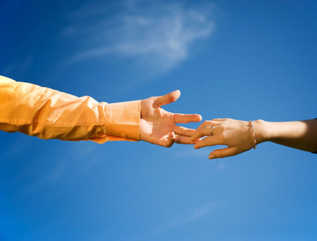 Couple hands in a blue sky close-upの写真素材