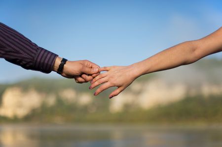 close-up couple hands in a blue sky backgroundの写真素材