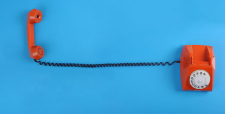 Picture of orange telephone over blue background. Many lot of copyspaceの写真素材