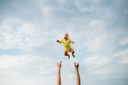 Father playing with baby. Very high jumpの写真素材