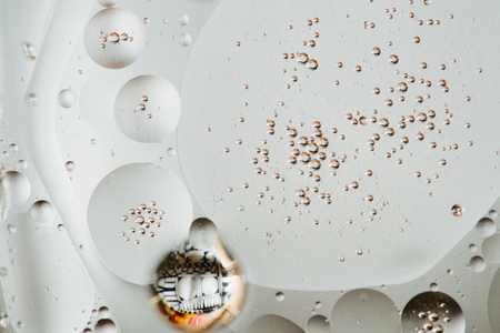 Macro shot of backlit water-oil emulsion over colored background.の写真素材