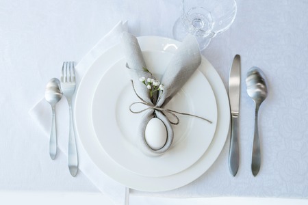 Simple festive Easter table setting with napkin Easter Bunny for one personの写真素材