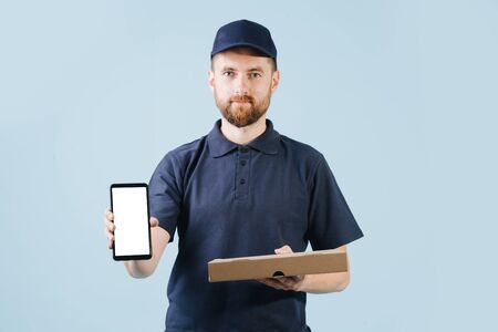 Courier is delivering pizza, holding smart phone in a hand for customer to signの写真素材