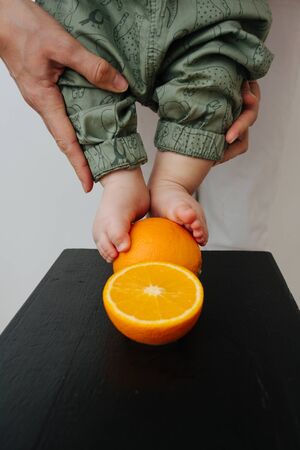 Close-up shot of baby's feet with orangeの写真素材