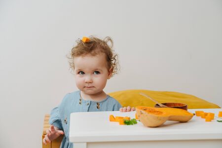 Portrait of a little girl with a piece of pumpkin on his headの写真素材