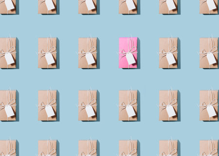 Texture of multiplied cardboard boxes with tags over blue background. Image of pink box placed near...