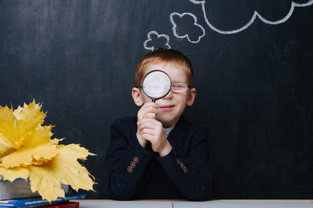 Little ginger boy in uniform is participating in a traditional first day of school portrait photo...