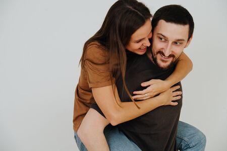 Middle age couple having fun. Woman riding on her man's back. Their faces close to one another. Half length, close up.の写真素材