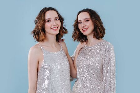 Two twin sisters, similar as two drops of water to each other. Studio close-up portraitの写真素材