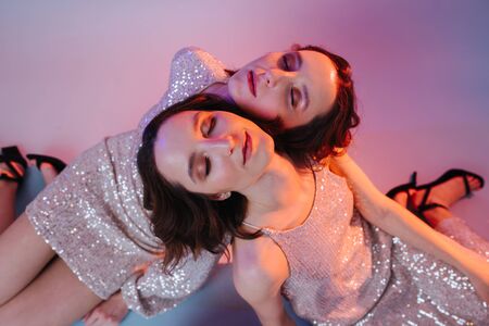 Sisterhood concept, Closeup portrait relax girls feel togetherness and kinship, they put their heads on each other's shoulders and close eyes.の写真素材