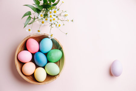 Easter picture, multi-colored eggs in a wooden plate, on a pink background. There is a place for...
