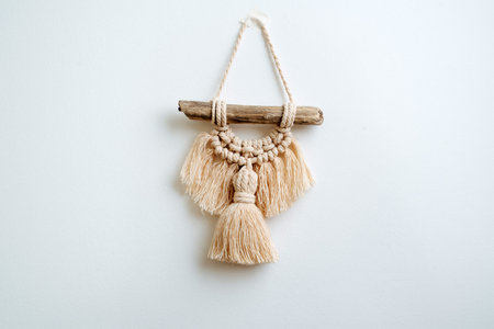 Small embroidery made in macrame technique, hangs on a white wall