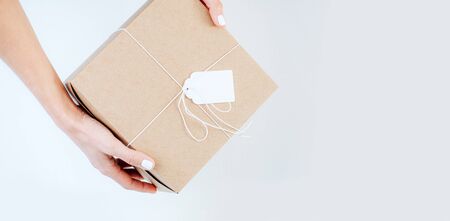 The girl's hands hold a craft box with a tag for the text. Close-upの写真素材