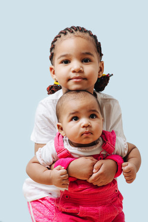 Happy mixed race family sitting on floor at home, father and mother watching little girl playing,...