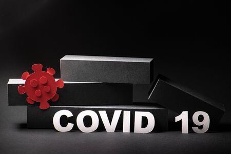 Fallen economic bar chart with covid19 word and red virus figure over black backgroundの写真素材