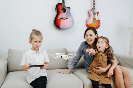Family spending time on a sofa in the living room, mom and her kids playing with quadcopter drone....
