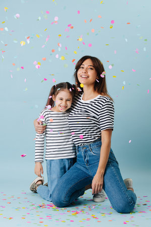 Two fashion lovers, mom and daughter wearing same clothes. They have jeans and black and white...