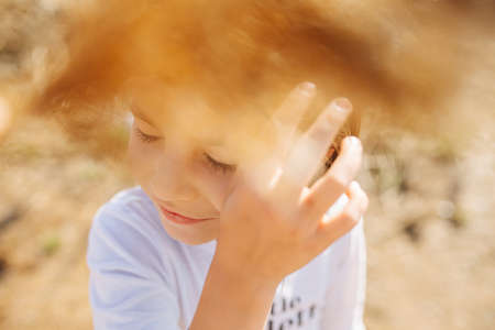 Little schoolgirl fixing her hair. Cereal fluffy ears in a foregroundの写真素材
