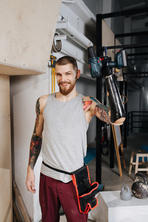Happy satisfied cyborg man with bionic hand posing with electric screwdriverの写真素材