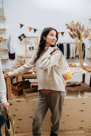 Sexy young woman in ecological shop posing for a photo with net bagの写真素材