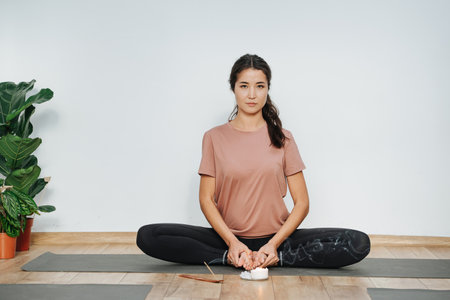 Smug woman practicing yoga, doing butterfly asana, turnig soles upwardの写真素材