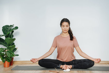 Peaceful woman practicing yoga, meditating in butterfly asana, her eyes closed
