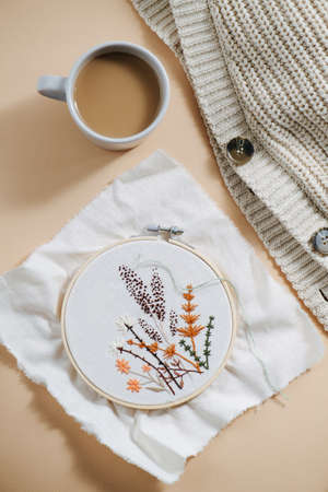 Embroidery in hoops, sweater and coffee on the table