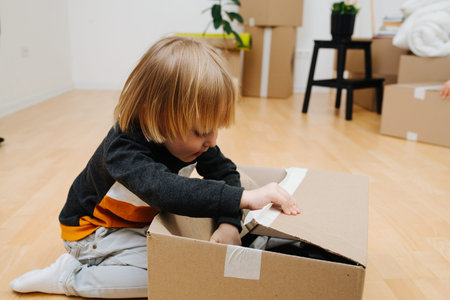 Portrait of little boy, he opens a box of things.