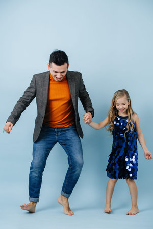 Funny barefoot father and daughter dancing twist, moving feet