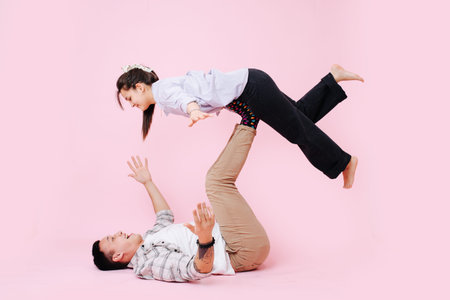 A man lifts a woman on her feet while she holds the balance.