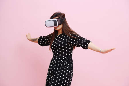 Young beautiful girl in flight arms outstretched, she VR glassesの写真素材