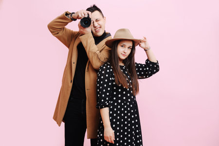 Photographer and model, portrait of couple on pink