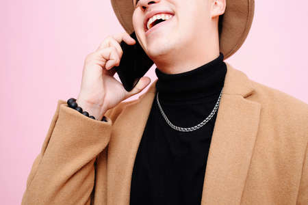 Portrait of a young man, he laughs talking on the phoneの写真素材