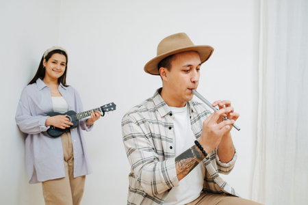 A man plays the Irish flute, and girl playing on a ukuleleの写真素材